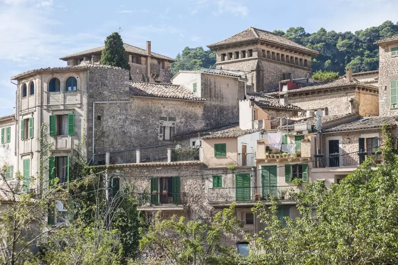 Mallorquinisches Bergdorf vor bewaldeten Bergen Mallorquinisches Bergdorf vor bewaldeten Bergen