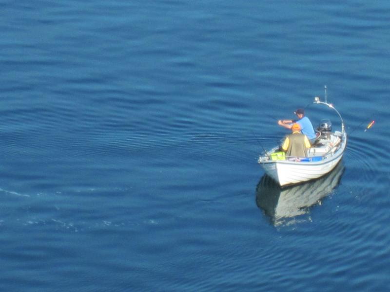 Angler in einem kleinen Motorboot auf ruhigem Wasser