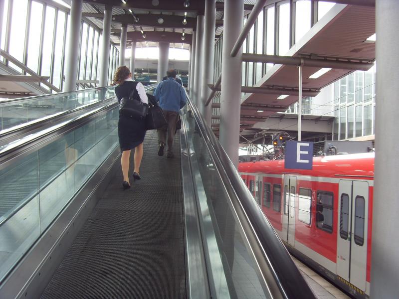 Reisende auf einer Flughafenverbindung mit Zug