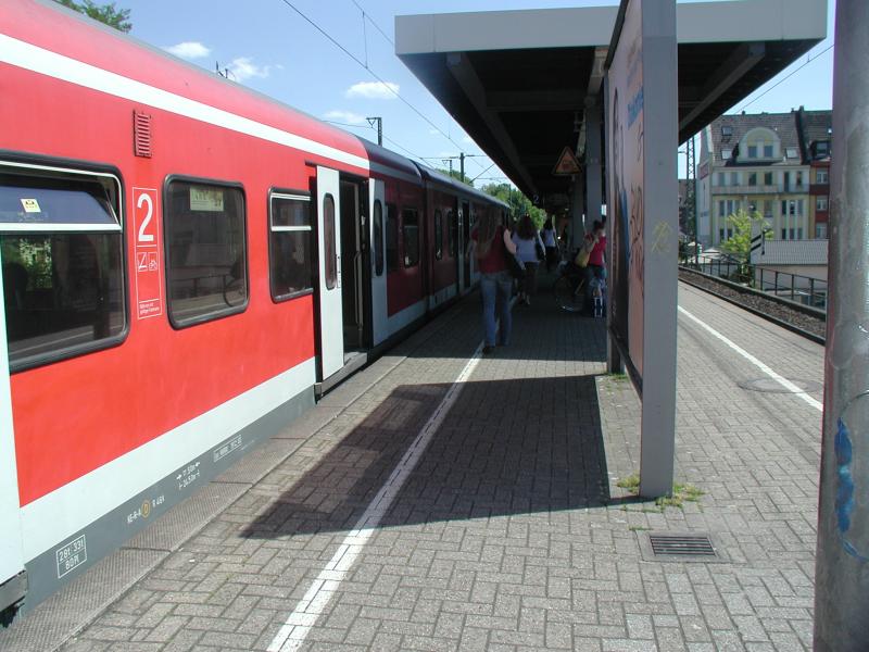 Roter Regionalzug am Bahnsteig mit Reisenden