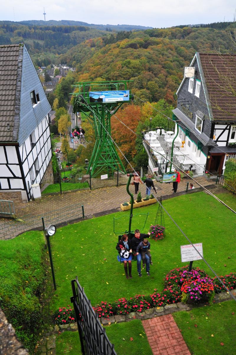 Familie fährt mit einer Seilbahn über eine bewaldete Landschaft