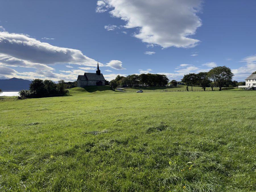 Alte Edøy-Kirche mit Feldern und dem historischen Edøy-Hof auf Edøya