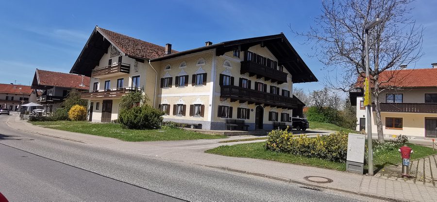 Ehemaliges Bauernhaus in der Hauptstraße von Chieming mit reich verziertem Putz und geschnitzter Tür
