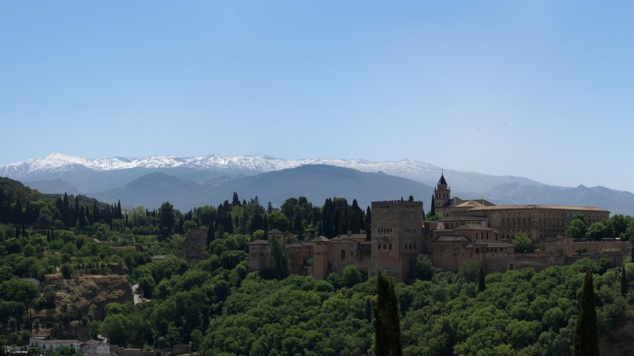 Panoramablick auf die Alhambra in Granada vor der Bergkulisse.