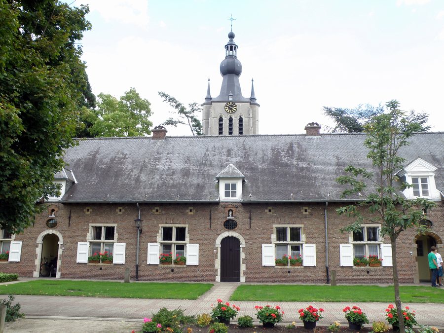Historischer Beginenhof von Aarschot mit dem Turm der gotischen Liebfrauenkirche im Hintergrund