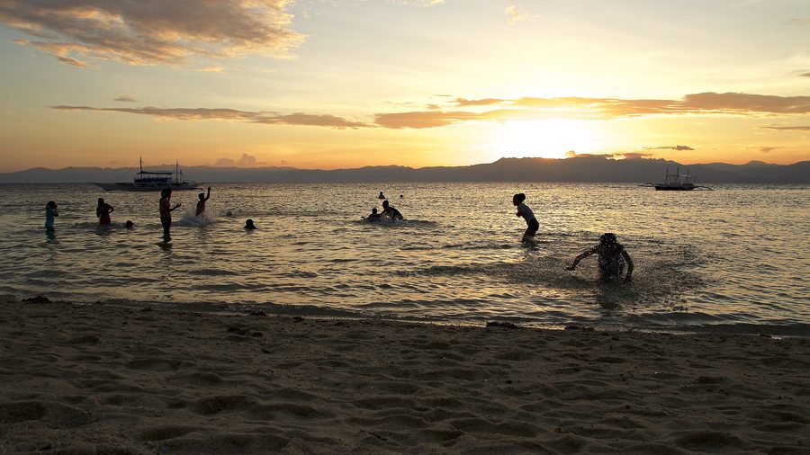 Kinder spielen am Panagsama Beach in Moalboal auf Cebu