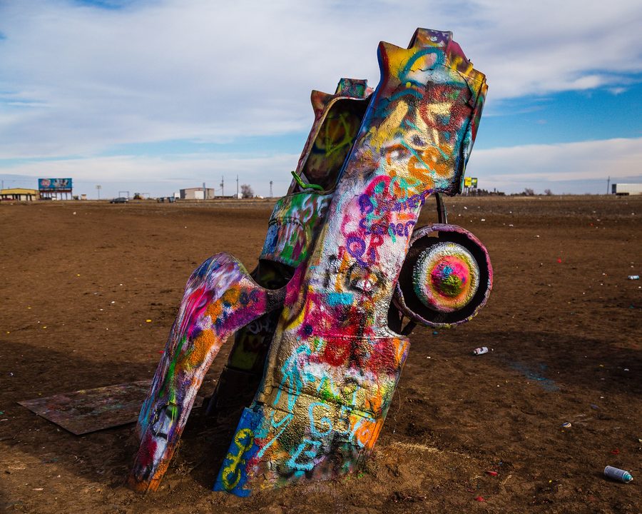 Bunt bemalte, halb im Boden versenkte Cadillacs an der Cadillac Ranch bei Amarillo, Texas