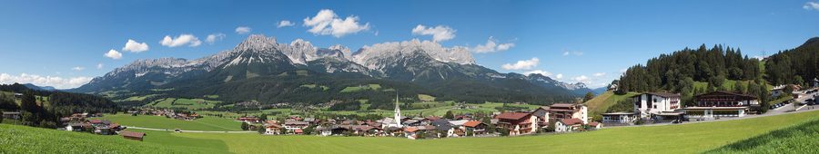 Bergdorf Ellmau mit grünen Hängen und einem breiten Tal im Sommer.