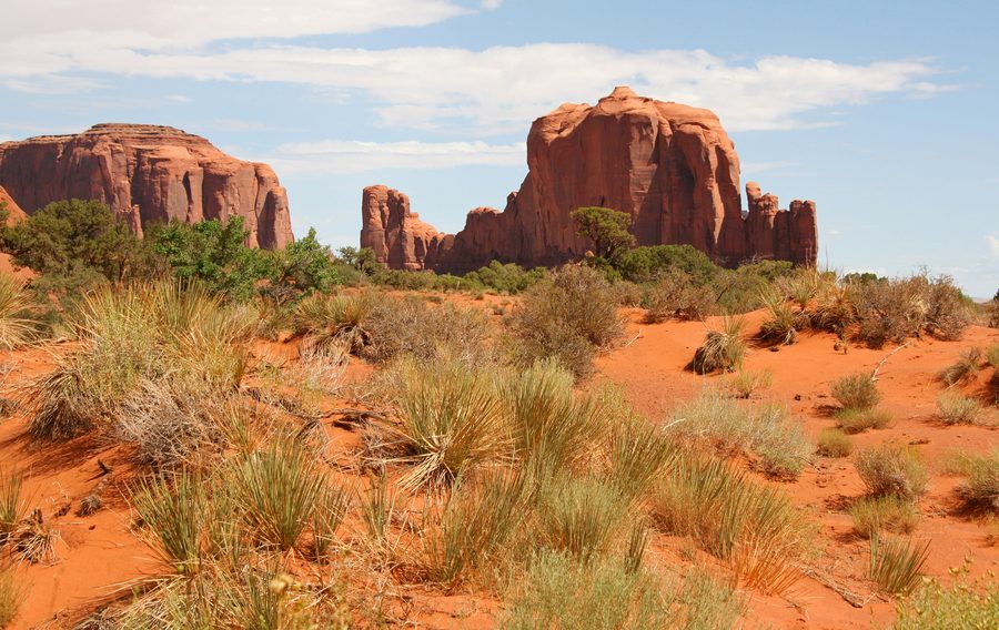 Monument Valley mesas and buttes in Arizona under a blue sky.