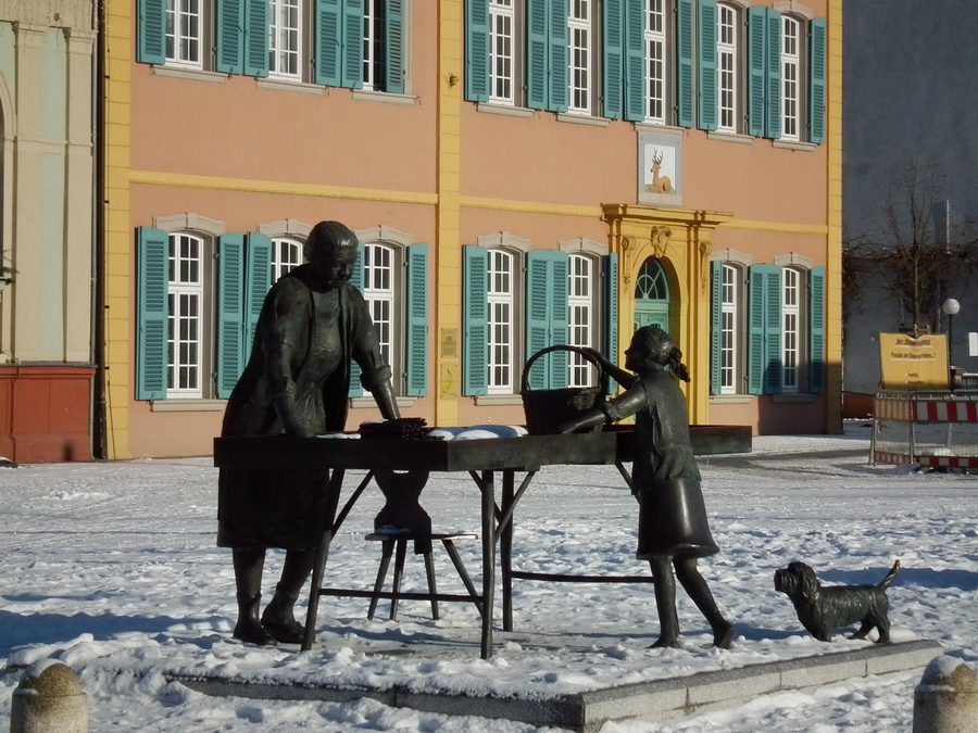 Spargelfrau auf dem Schwetzinger Schlossplatz mit dem Palais Hirsch im Hintergrund