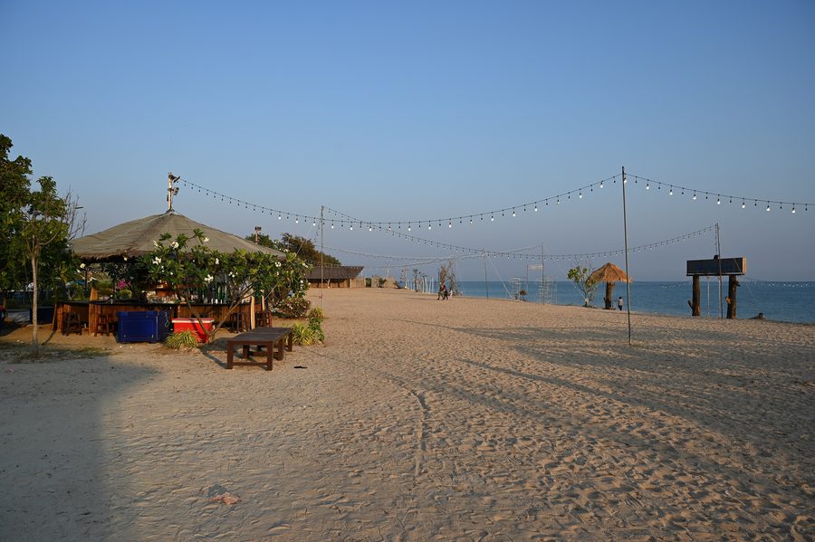 Ruhiger Sandstrand in Ban Chang mit einer Strandhütte und Lichterketten