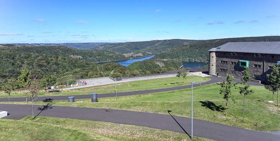 Gebäude der ehemaligen Ordensburg Vogelsang im Nationalpark Eifel mit dem Urftstausee im Hintergrund