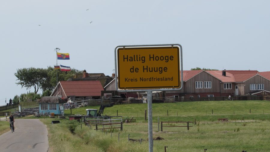 Zweisprachiges Ortsschild der Hallig Hooge vor der Backenswarft