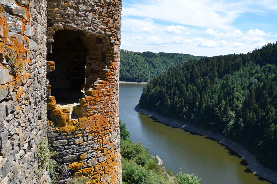 Château d'Alleuze auf einem Felsvorsprung in der Landschaft des Cantal