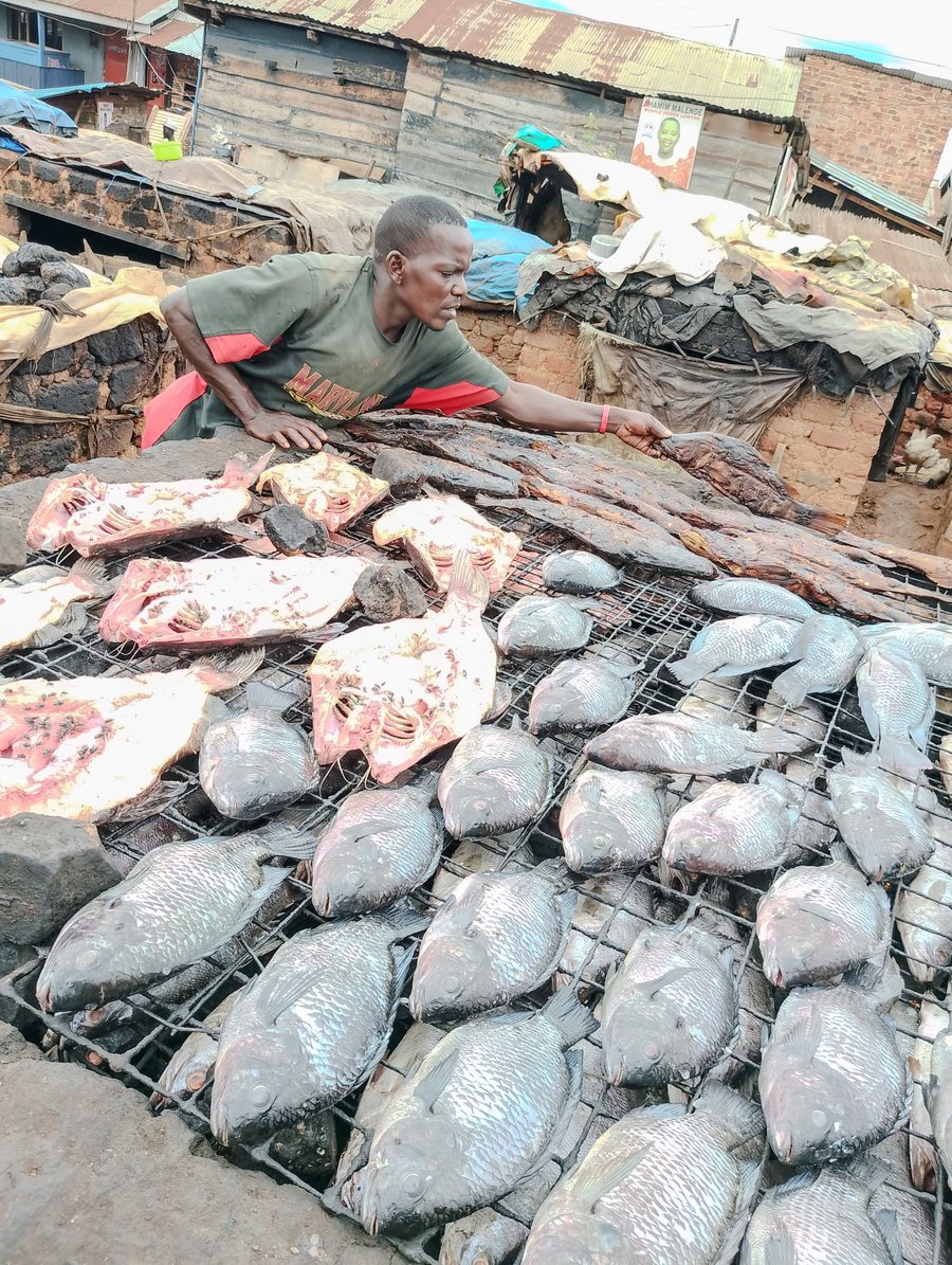 Fischverkäuferin mit traditionell geräuchertem und frischem Fisch am Ggaba Landing Site in Uganda