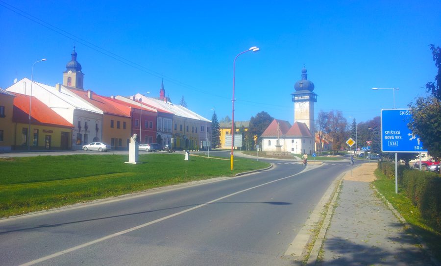 Námestie v Spišských Vlachoch s Kostolnou ulicou, kruhovým objazdom a Kostolom Nanebovzatia Panny Márie