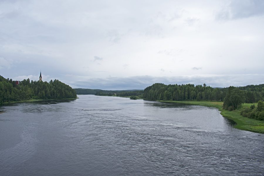 Die Vindelälven bei Vindeln, gesehen von einer Brücke flussabwärts, umgeben von Waldlandschaft