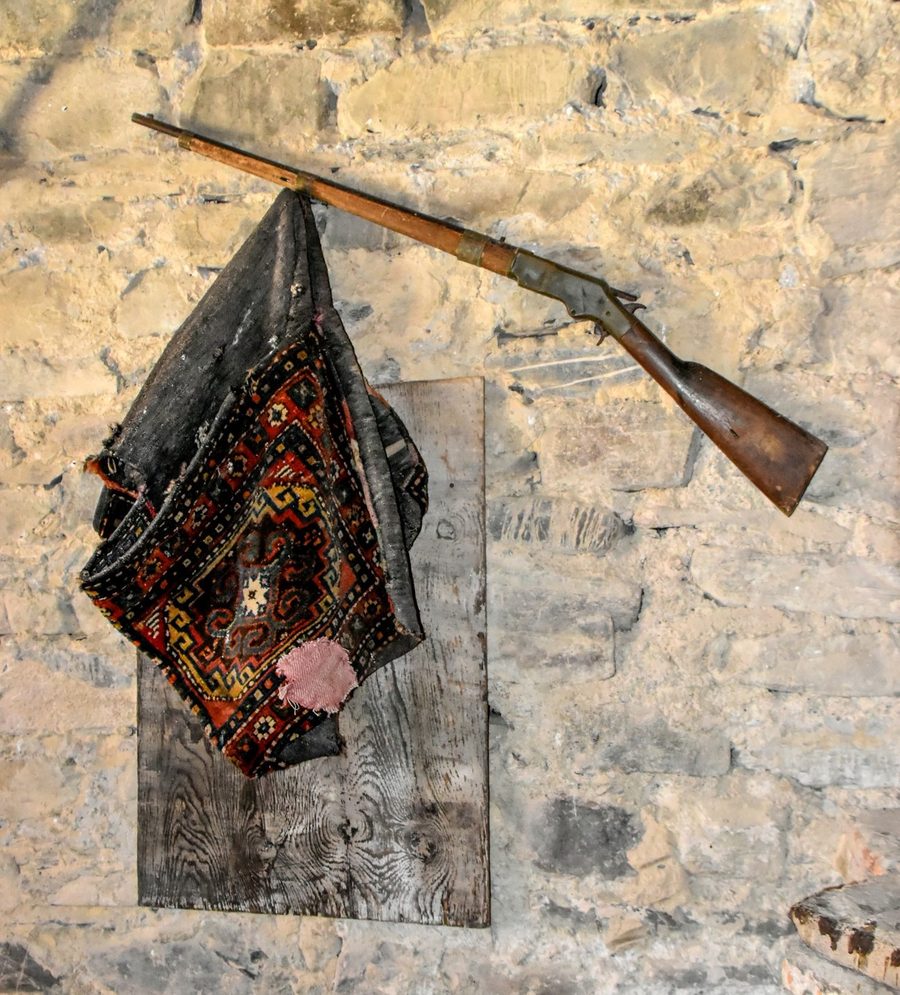 Innenraum des Vazha-Pshavela-Hausmuseums in Chargali mit einem Gewehr an der Wand.