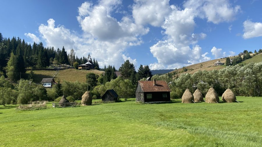 Dorf Poiana Horea mit Heuschobern, Kirche und Friedhof im Apuseni-Gebirge