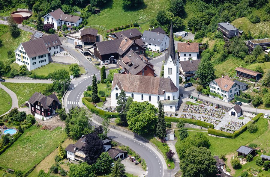 Luftbild der Pfarrkirche Hl. Agnes und des Friedhofs in Klaus in Vorarlberg