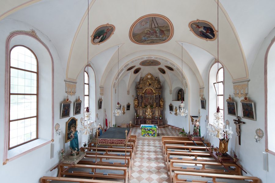 Kirchplatz in Huben im Ötztal mit dörflicher Bebauung