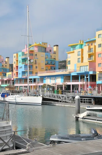 Bunte Ferienwohnungen an einer Marina mit Booten im Vordergrund